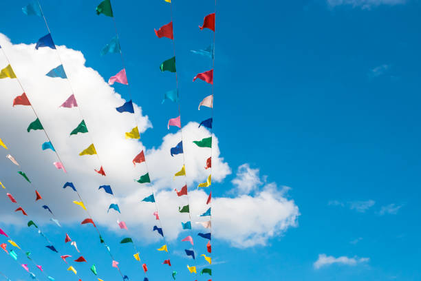 istock Multi-colored flags against a blue sky with clouds and a dome of a church. 1049682624