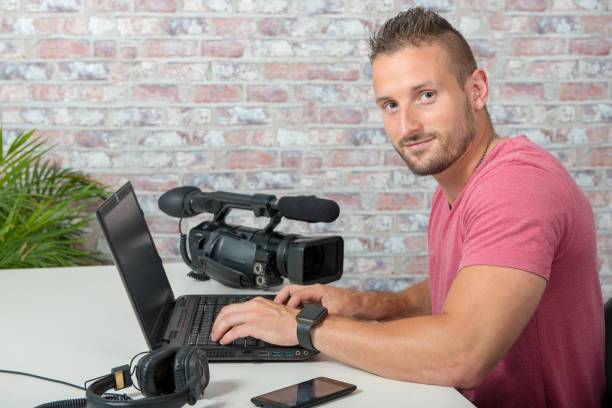 istock video editor with laptop  and professional video camera 1049688346