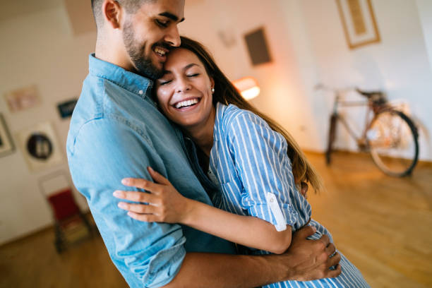 istock Beautiful couple hugging and smiling at home 1049688520