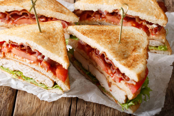 istock layer club sandwich with turkey meat, bacon, tomatoes and lettuce macro. horizontal 1049690306