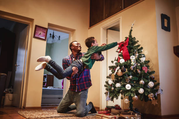 istock Father playing with his son next to the Christmas tree 1049694050