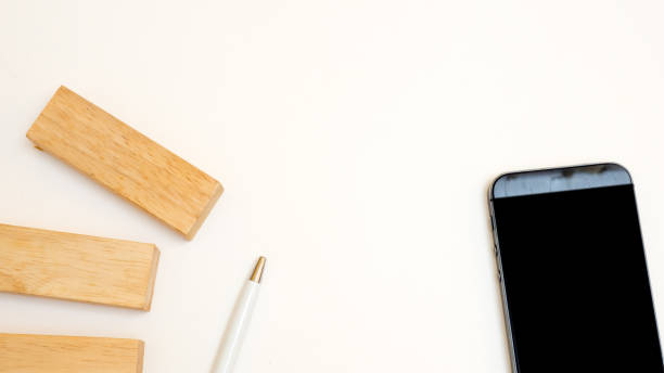 istock top view smart phone with woodenblock white background 1049694304