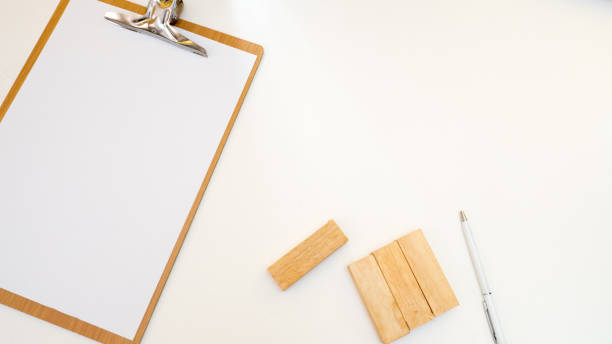 istock top view paper board with woodenblock white background 1049694322