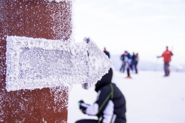 A snowy descent sign in the mountain ski resort and mountains in the background Downhill and freeride