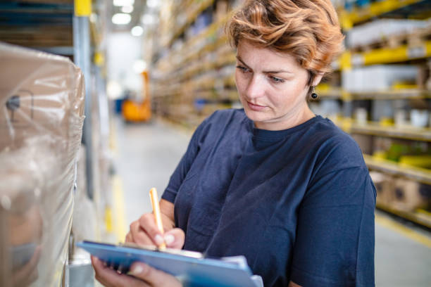 istock Woman checking boxes in warehouse 1049697508