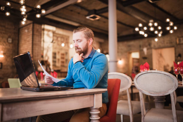 istock Young, redhead businessman, on coffee break working on laptop. 1049697510