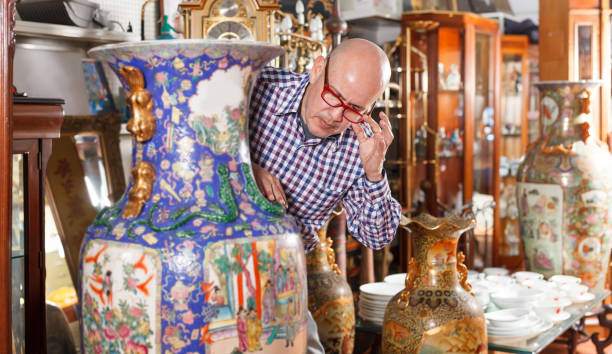 istock male  looking at antique oriental vase 1049697626