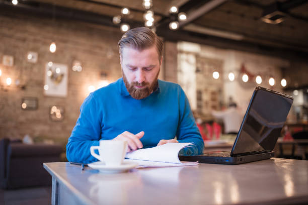 istock Young, redhead businessman, on coffee break, using laptop 1049697924