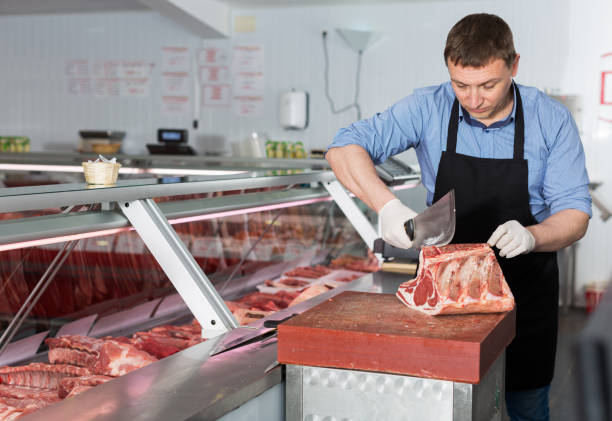 istock Butcher cutting raw steak on ribs 1049700828