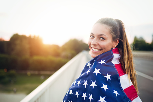 Beautiful young woman wrapped in American flag