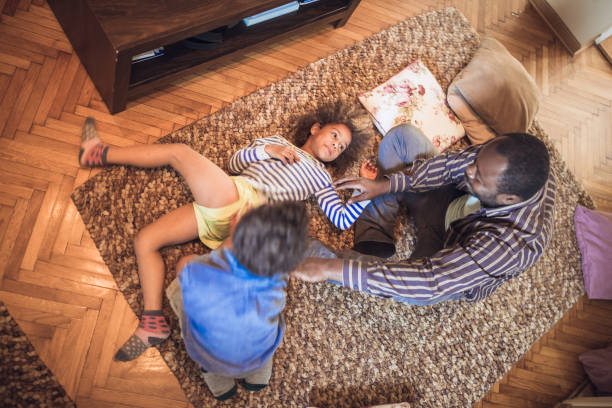 istock Kids having fun at home, playing with their father at home. 1049711432