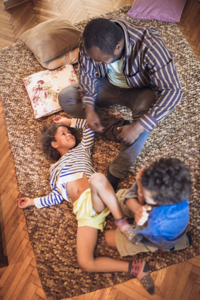 istock Kids having fun at home, playing with their father at home. 1049711458