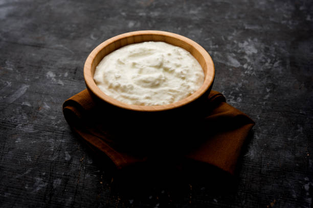 istock Plain curd or yogurt or Dahi in Hindi, served in a bowl over moody background. Selective focus 1049714570