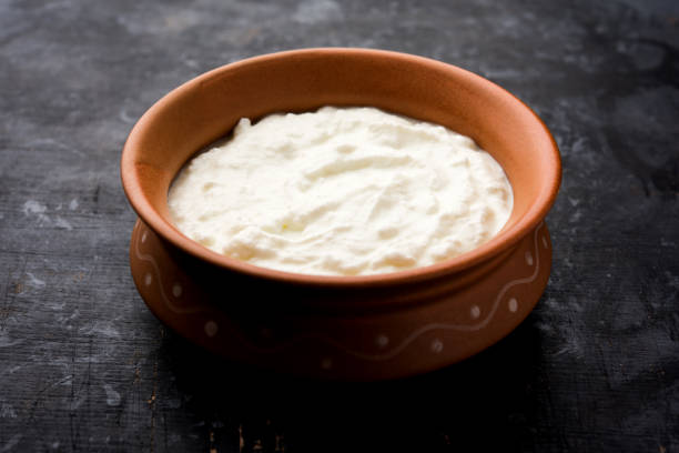 istock Plain curd or yogurt or Dahi in Hindi, served in a bowl over moody background. Selective focus 1049714700