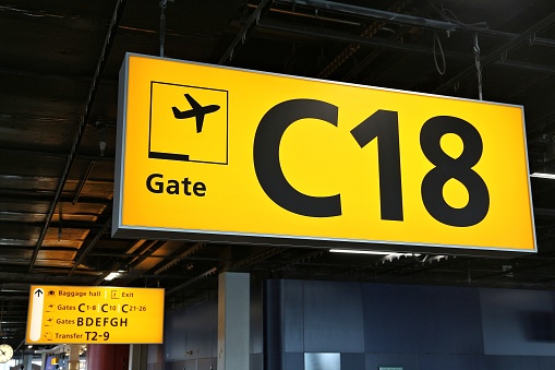Generic airport signage in Amsterdam. Illuminated gates sign.