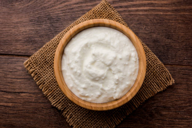 istock Plain curd or yogurt or Dahi in Hindi, served in a bowl over moody background. Selective focus 1049714824