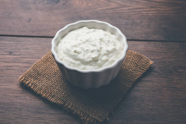 istock Plain curd or yogurt or Dahi in Hindi, served in a bowl over moody background. Selective focus 1049714952