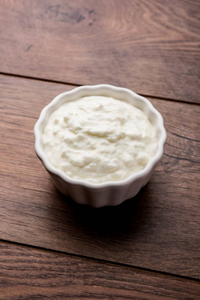 istock Plain curd or yogurt or Dahi in Hindi, served in a bowl over moody background. Selective focus 1049715100