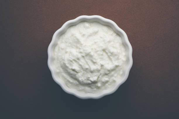 istock Plain curd or yogurt or Dahi in Hindi, served in a bowl over moody background. Selective focus 1049717424