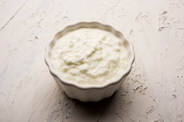 istock Plain curd or yogurt or Dahi in Hindi, served in a bowl over moody background. Selective focus 1049717700