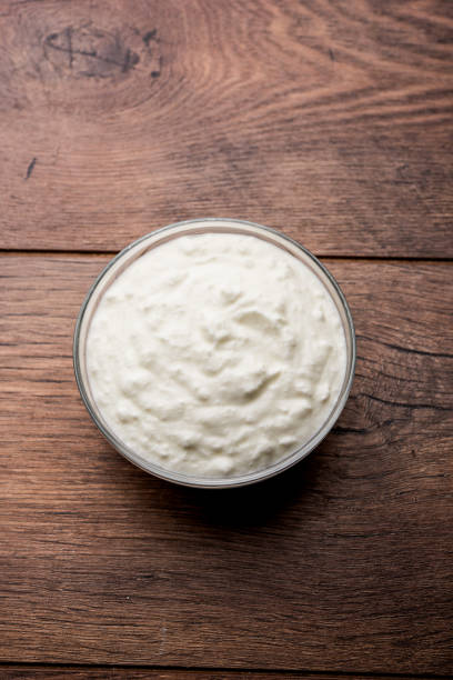 Plain curd or yogurt or Dahi in Hindi, served in a bowl over moody background. Selective focus