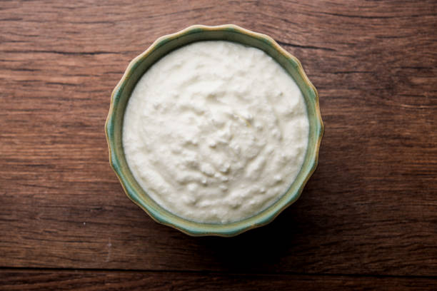 istock Plain curd or yogurt or Dahi in Hindi, served in a bowl over moody background. Selective focus 1049718200