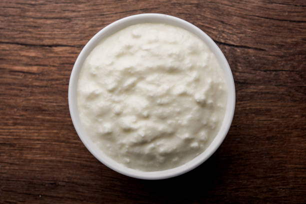 istock Plain curd or yogurt or Dahi in Hindi, served in a bowl over moody background. Selective focus 1049718386