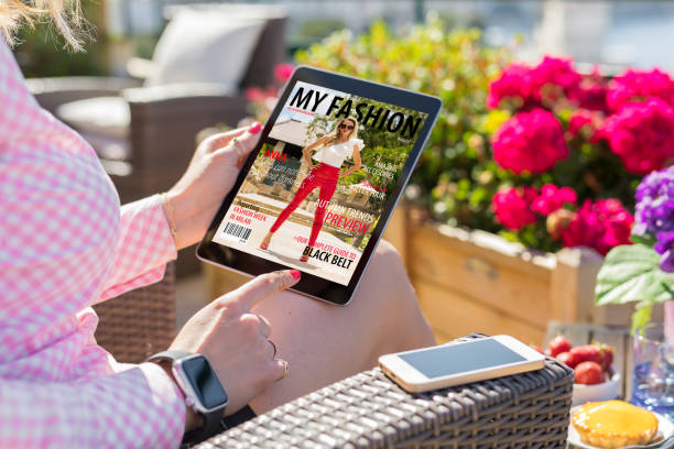istock Woman looking at magazine cover on digital tablet 1049718676