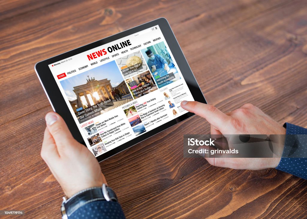 Sample online news website on tablet Sample online news website on tablet, unrecognizable male using tablet, top view. Newspaper Stock Photo