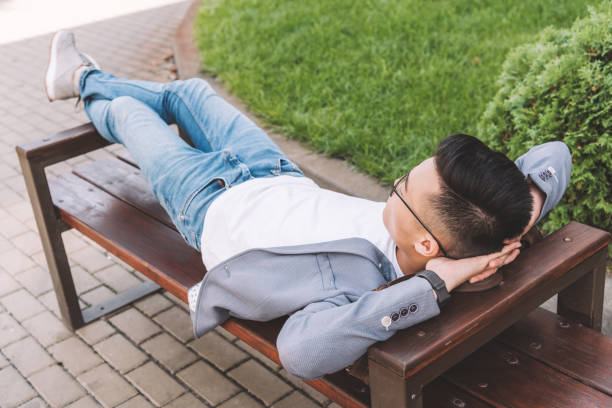 istock stylish man in gray jacket resting on bench 1049719306