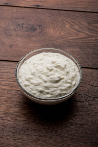 istock Plain curd or yogurt or Dahi in Hindi, served in a bowl over moody background. Selective focus 1049721418