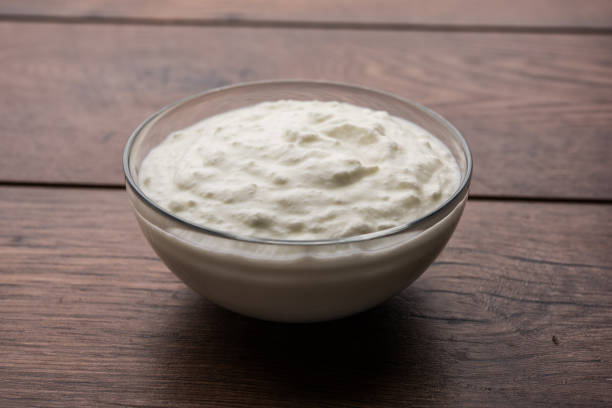 Plain curd or yogurt or Dahi in Hindi, served in a bowl over moody background. Selective focus