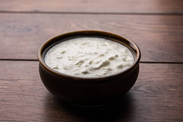istock Plain curd or yogurt or Dahi in Hindi, served in a bowl over moody background. Selective focus 1049721572