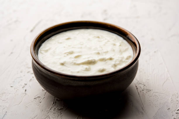 istock Plain curd or yogurt or Dahi in Hindi, served in a bowl over moody background. Selective focus 1049721598