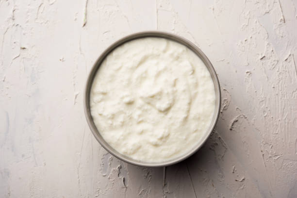 istock Plain curd or yogurt or Dahi in Hindi, served in a bowl over moody background. Selective focus 1049721642