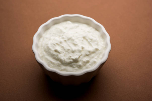 istock Plain curd or yogurt or Dahi in Hindi, served in a bowl over moody background. Selective focus 1049721876