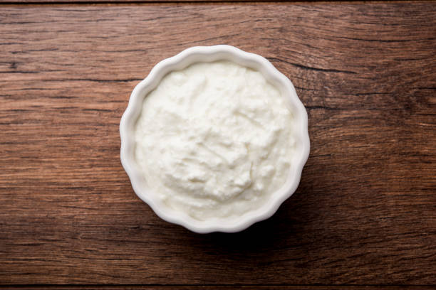 istock Plain curd or yogurt or Dahi in Hindi, served in a bowl over moody background. Selective focus 1049722020