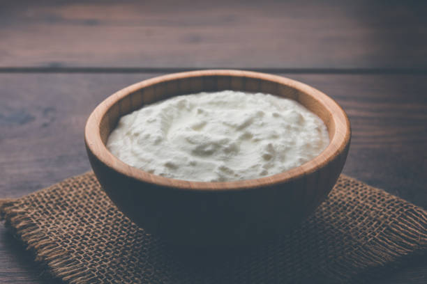 istock Plain curd or yogurt or Dahi in Hindi, served in a bowl over moody background. Selective focus 1049722194