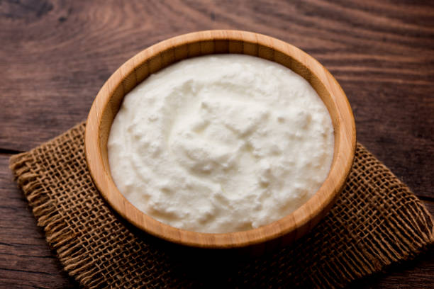 istock Plain curd or yogurt or Dahi in Hindi, served in a bowl over moody background. Selective focus 1049722206
