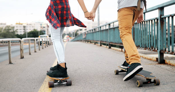 istock Young attractive couple riding skateboards and having fun 1049724476