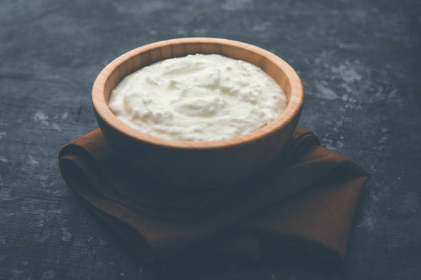 istock Plain curd or yogurt or Dahi in Hindi, served in a bowl over moody background. Selective focus 1049724670