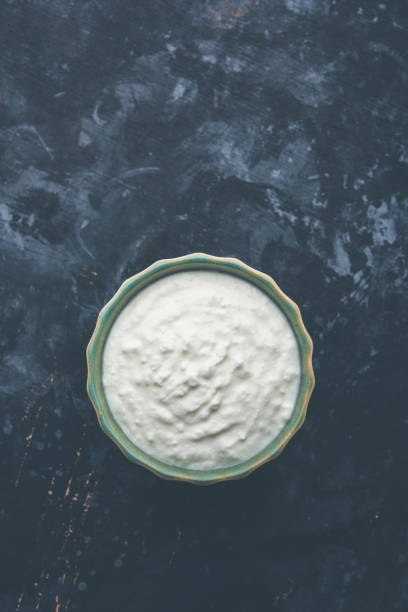 istock Plain curd or yogurt or Dahi in Hindi, served in a bowl over moody background. Selective focus 1049725402