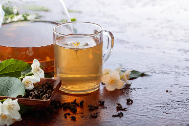 istock Green tea with jasmine in cup and teapot on old copper table. 1049725810