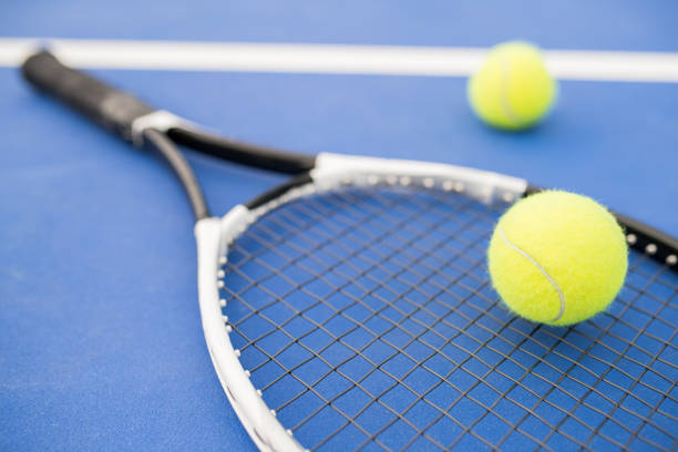 Tennis Racket on Blue Sports background of yellow tennis ball  and racket laying on blue floor in court, copy space drive ball sports photos stock pictures, royalty-free photos & images