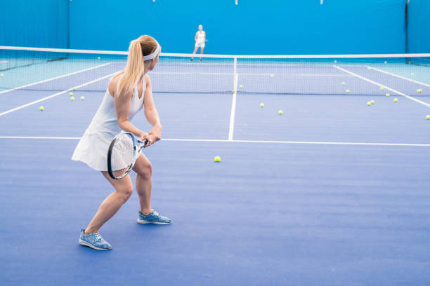 istock Two Women Playing Tennis 1049728008