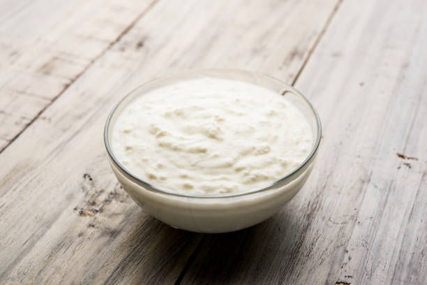 istock Plain curd or yogurt or Dahi in Hindi, served in a bowl over moody background. Selective focus 1049728022