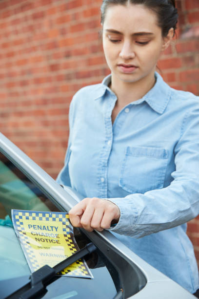 istock Frustrated Male Motorist Looking At Parking Ticket 1049728314