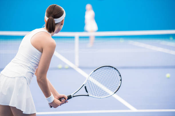 Rear view of female tennis player holding racket during match in court, copy space