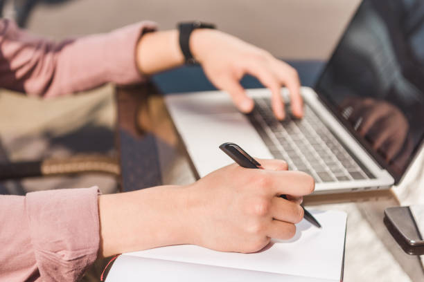 istock partial view of man remote working on laptop and making notes at tabletop 1049728500