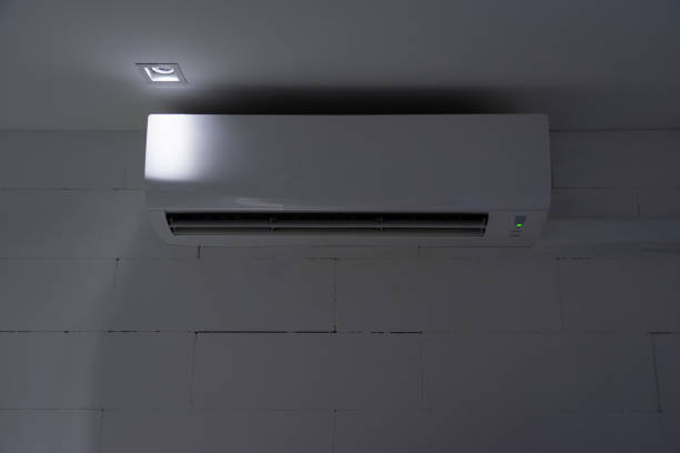 White split air conditioner on wall at night stock photo